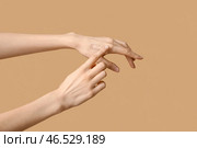 Женщина наносит тональный крем на коричневом фоне. Стоковое фото, фотограф Pixel_shot / Фотобанк Лори