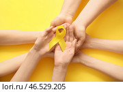 Женщина, держащая жёлтую ленту на цветном фоне. Концепция саркомы. Стоковое фото, фотограф Pixel_shot / Фотобанк Лори
