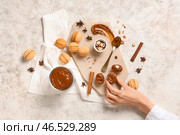 Женщина берет вкусные орешки с вареной сгущенкой на белом потертом столе. Стоковое фото, фотограф Pixel_shot / Фотобанк Лори