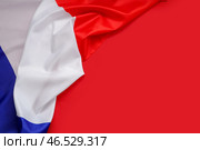 Скомканный флаг Франции на красном фоне. Празднование Дня взятия Бастилии. Стоковое фото, фотограф Pixel_shot / Фотобанк Лори