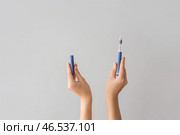 Женские руки с инсулиновым шприцем на сером фоне. Стоковое фото, фотограф Pixel_shot / Фотобанк Лори
