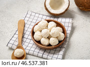 Деревянная чаша с вкусными кокосовыми конфетами на белом столе. Стоковое фото, фотограф Pixel_shot / Фотобанк Лори