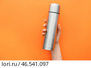 Женская рука с термосом на цветном фоне. Стоковое фото, фотограф Pixel_shot / Фотобанк Лори