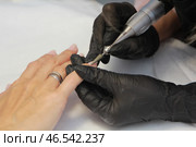 Beautician removing cuticle using electric nail file machine in beauty salon. Стоковое фото, фотограф Юрий Поздников / Фотобанк Лори