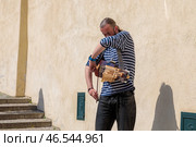 Street musician playing hurdy gurdy in urban setting. Prague, April 15, 2018, Czech Republic. Редакционное фото, фотограф Юрий Поздников / Фотобанк Лори