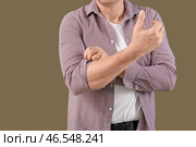 Зрелый мужчина закатывает рукав на зеленом фоне, крупным планом. Стоковое фото, фотограф Pixel_shot / Фотобанк Лори