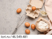 Мешок с пшеничной мукой, яйцами и венчиком на сером гранжевом столе. Стоковое фото, фотограф Pixel_shot / Фотобанк Лори