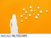 Бумажная женская фигура с гормональными таблетками на оранжевом фоне. Стоковое фото, фотограф Pixel_shot / Фотобанк Лори