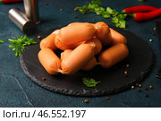 Доска со вкусными вареными сосисками и петрушкой на темном фоне. Стоковое фото, фотограф Pixel_shot / Фотобанк Лори