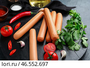 Доска вкусных колбас с петрушкой и помидорами на темном фоне. Стоковое фото, фотограф Pixel_shot / Фотобанк Лори