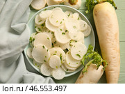 Миска с ломтями свежего редьки на зеленом деревянном фоне. Стоковое фото, фотограф Pixel_shot / Фотобанк Лори