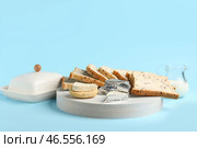 Доска с треугольниками вкусного обработанного сыра и грилями на голубом фоне. Стоковое фото, фотограф Pixel_shot / Фотобанк Лори