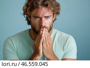 Задумчивый мужчина с серьезным выражением лица и сложенными руками, портрет на голубом фоне. Стоковое AI-изображение, AI-художник Щеголева Ольга / Фотобанк Лори
