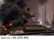 Sestroretsk, Russia - February 19, 2023: Amidst swirling smoke and flames, soldiers engage in fierce combat while restoring historical winter battle experiences inspired by the Second World War. Редакционное фото, фотограф Aleksandr Golubev / Фотобанк Лори