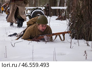 Sestroretsk, Russia - February 19, 2023: Soldiers reenact winter combat, skillfully maneuvering in deep snow while staying in tactical positions, echoing historical strategies. Редакционное фото, фотограф Aleksandr Golubev / Фотобанк Лори