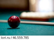 Russian billiards. Red and white balls are lying on a green billiard table. Spending time at home playing a hobby sports game. Стоковое фото, фотограф Photojuli / Фотобанк Лори