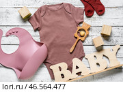 Детская одежда, слюнявчик и игрушки на светлом деревянном фоне. Стоковое фото, фотограф Pixel_shot / Фотобанк Лори