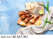 Вкусные куриные голени с хлебом на цветном фоне. Стоковое фото, фотограф Pixel_shot / Фотобанк Лори