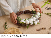 Женщина плетет красивый пасхальный венок за столом, крупным планом. Стоковое фото, фотограф Pixel_shot / Фотобанк Лори