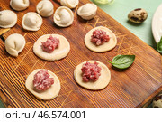 Сырое тесто с мелким мясом и неприготовленные пельмени на столе. Стоковое фото, фотограф Pixel_shot / Фотобанк Лори