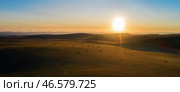 Panoramic view of a mountain plateau with golden mowed field and many straw bales in the warm rays of the rising sun. Aerial photo. Стоковое фото, фотограф Роман Дзюбало / Фотобанк Лори