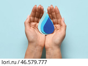 Женские руки с каплями бумаги на голубом фоне. Всемирный день полиомиелита. Стоковое фото, фотограф Pixel_shot / Фотобанк Лори