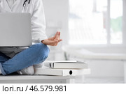 Женский врач с ноутбуком, медитирующая на столе в клинике, крупным планом. Стоковое фото, фотограф Pixel_shot / Фотобанк Лори