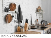 Доска с крючками для размещения разделочных досок и кухонных принадлежностей на деревянных стойках в интерьере современной кухни. Стоковое фото, фотограф Pixel_shot / Фотобанк Лори