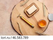 Доска с массажером для лица, эфирным маслом и мылом на цветном фоне. Стоковое фото, фотограф Pixel_shot / Фотобанк Лори