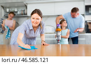 Smiling woman cleaning apartment together with husband and daughters. Стоковое фото, фотограф Яков Филимонов / Фотобанк Лори