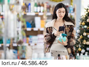 Female client scanning QR code on package tile cleaner spray. Стоковое фото, фотограф Яков Филимонов / Фотобанк Лори