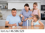 Dissatisfied woman demanding money from perplexed husband at home. Стоковое фото, фотограф Яков Филимонов / Фотобанк Лори