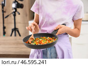 Молодая женщина с жареными овощами записывает видеоурок по кулинарии на кухне, крупный план. Стоковое фото, фотограф Pixel_shot / Фотобанк Лори