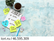 Липкие заметки с планами дел, блокнот и чашка кофе на синем фоне с эффектом гранжа. Концепция новогодних целей. Стоковое фото, фотограф Pixel_shot / Фотобанк Лори