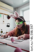 Excited female gamer in bunny ears immersed in Easter-themed gaming session. Holding controller, she smiles, surrounded by play interior, decorated eggs, and playful holiday vibes. Стоковое видео, видеограф Енваев Андрей / Фотобанк Лори