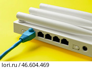 Маршрутизатор Wi-Fi с антеннами и сетевым кабелем на цветном фоне. Стоковое фото, фотограф Pixel_shot / Фотобанк Лори