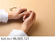 Руки молящегося мусульманина с тасбихом на цветном фоне. Стоковое фото, фотограф Pixel_shot / Фотобанк Лори