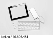 Планшетный компьютер, внешний аккумулятор, наушники и клавиатура на белом фоне. Стоковое фото, фотограф Pixel_shot / Фотобанк Лори