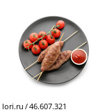 Тарелка шашлыков с вкусным люля-кебабом, помидорами и соусом на белом фоне. Стоковое фото, фотограф Pixel_shot / Фотобанк Лори