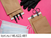 Бумажные пакеты с маникюрным оборудованием, медицинскими масками и перчатками на цветном фоне. Стоковое фото, фотограф Pixel_shot / Фотобанк Лори