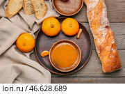 Чаша вкусного мандаринового джема и хлеба на деревянном фоне. Стоковое фото, фотограф Pixel_shot / Фотобанк Лори