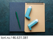 Ингаляторы от астмы, ручка и блокноты на темном фоне. Стоковое фото, фотограф Pixel_shot / Фотобанк Лори