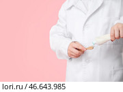 Маленький дантист с пастой и зубной щеткой на цветном фоне, крупным планом. Стоковое фото, фотограф Pixel_shot / Фотобанк Лори
