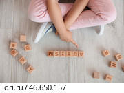 Маленькая девочка с аутичным расстройством играет с кубиками на полу, вид сверху. Стоковое фото, фотограф Pixel_shot / Фотобанк Лори