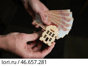 Банкноты номиналом 5000 российских рублей и деревянный домик. Стоковое фото, фотограф Алексей Белкин/NEWS.ru / ТАСС / Фотобанк Лори