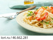 Тарелка с вкусными креветками и пастой на столе. Стоковое фото, фотограф Pixel_shot / Фотобанк Лори
