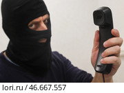 Мошенник в черной балаклаве с телефонной трубкой в руке. А. Стоковое фото, фотограф Белкин/Бизнес Online / ТАСС / Фотобанк Лори