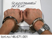 Наручники на арестованном преступнике и папка-скоросшиватель "Дело № 11001 Иностранный агент". Алексей Белкин/NEWS.ru/TACC. Стоковое фото, фотограф Белкин Алексей / ТАСС / Фотобанк Лори