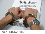 Наручники на арестованном преступнике и папка-скоросшиватель "Дело № 11001 Иностранный агент". Алексей Белкин/NEWS.ru/TACC. Стоковое фото, фотограф Белкин Алексей / ТАСС / Фотобанк Лори