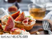 Вкусный бутерброд со спелым инжиром и прошутто на деревянной доске, крупным планом. Стоковое фото, фотограф Pixel_shot / Фотобанк Лори